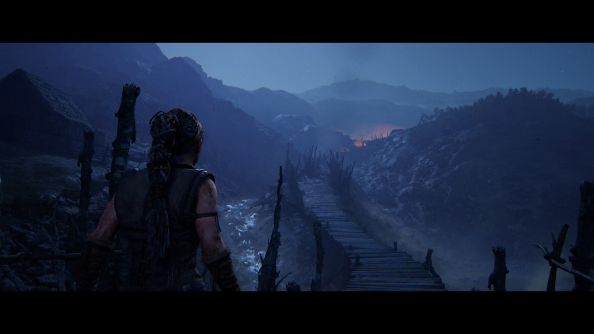 Senua looks down into a dark, imposing valley in Senua's Saga: Hellblade 2 from Ninja Theory.